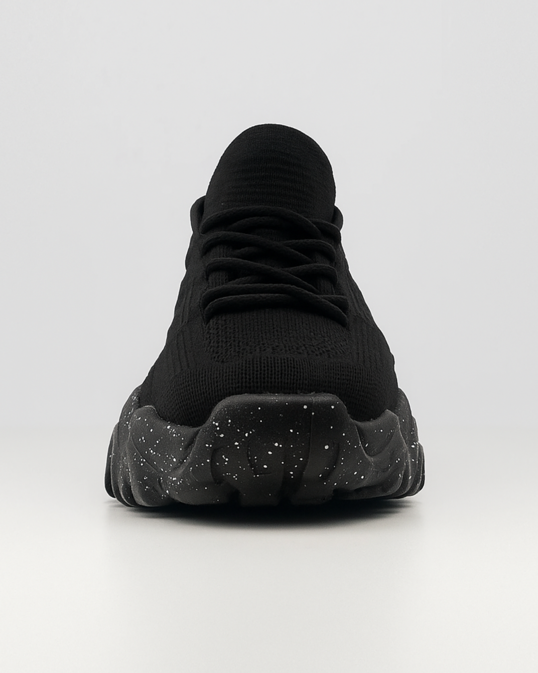 Frontal view of the black OrthoEase Luxe sneaker showing toe box and lace design with cushioned sole.