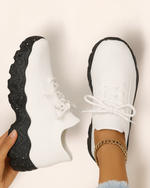 Top view of OrthoEase Luxe Reverse sneakers with white upper and speckled black sole