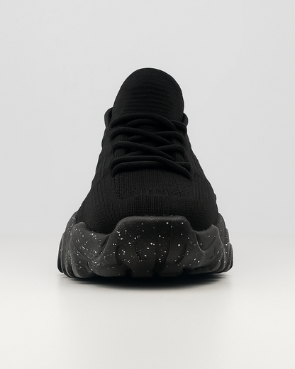 Frontal view of the black OrthoEase Luxe sneaker showing toe box and lace design with cushioned sole.